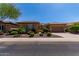 Charming single-story home boasts meticulously landscaped front yard, attached garage and solar panels, under a bright blue sky at 20283 N 273Rd Ave, Buckeye, AZ 85396