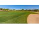 Expansive golf course view featuring green fairways and a sand trap, illustrating the recreational opportunities within the community at 20283 N 273Rd Ave, Buckeye, AZ 85396
