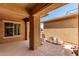 Covered patio featuring elegant columns, designer flooring, and picturesque landscaping, perfect for outdoor living at 20283 N 273Rd Ave, Buckeye, AZ 85396