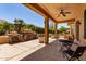 Beautiful covered patio with brick pillars, stone decor, fan and outdoor seating at 20283 N 273Rd Ave, Buckeye, AZ 85396