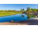 Picturesque pond with clear blue water, surrounded by golf course and trees, highlighting the community's natural beauty at 20283 N 273Rd Ave, Buckeye, AZ 85396