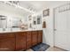 Bright bathroom with dual sinks, dark cabinets, and a large mirror at 2048 S Martingale Rd, Gilbert, AZ 85295