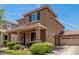 Two story home boasting a covered porch, a two car garage and lush, well-maintained front yard at 2048 S Martingale Rd, Gilbert, AZ 85295