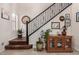 Bright foyer with staircase, showcasing a decorative mirror, art pieces, and a stylish wood cabinet at 2048 S Martingale Rd, Gilbert, AZ 85295