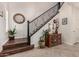 Elegant foyer featuring a staircase with iron railings, wood accents, and a decorative display cabinet at 2048 S Martingale Rd, Gilbert, AZ 85295