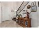 Inviting foyer featuring a staircase with a black railing, artwork, and a charming display cabinet at 2048 S Martingale Rd, Gilbert, AZ 85295