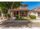Charming two-story home featuring a covered front porch, manicured landscaping, and a welcoming facade at 2048 S Martingale Rd, Gilbert, AZ 85295