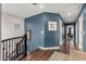 A beautifully designed hallway with wood floors, blue accent wall, and staircase leading to the upper level at 2048 S Martingale Rd, Gilbert, AZ 85295