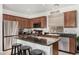 Well-appointed kitchen features granite countertops, stainless steel appliances, and an island with seating at 2048 S Martingale Rd, Gilbert, AZ 85295