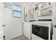 Functional laundry room with white washer and dryer and storage shelves at 2048 S Martingale Rd, Gilbert, AZ 85295