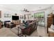 Spacious living room with comfortable leather furniture, ceiling fan, and sliding glass door to patio at 2048 S Martingale Rd, Gilbert, AZ 85295