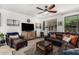 Bright living room offering a comfortable leather sofa, ceiling fan, and neutral décor at 2048 S Martingale Rd, Gilbert, AZ 85295