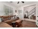 Inviting living room features a comfortable brown sectional, wood floors, and staircase access at 2048 S Martingale Rd, Gilbert, AZ 85295