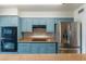 Modern kitchen featuring stainless steel appliances, blue cabinets, and granite countertops at 2114 E Sesame St, Tempe, AZ 85283