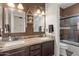 Bathroom featuring dual sinks, granite countertops, and a glass-enclosed shower at 22634 N 47Th Pl, Phoenix, AZ 85050