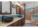 Bathroom featuring dual vessel sinks, tile counters and blue tile accents at 22634 N 47Th Pl, Phoenix, AZ 85050