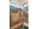 Custom tiled shower featuring tile accents, a shower seat and arched window at 22634 N 47Th Pl, Phoenix, AZ 85050