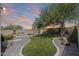 Backyard featuring a pool with rock waterfall feature and artificial turf, perfect for low-maintenance outdoor living at 2762 E Clifton Ave, Gilbert, AZ 85295