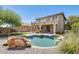 Inviting backyard with a sparkling pool, lush landscaping, and a two-story home in the background at 2762 E Clifton Ave, Gilbert, AZ 85295