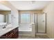 Bright bathroom featuring double vanity, soaking tub, and glass-enclosed shower at 2762 E Clifton Ave, Gilbert, AZ 85295