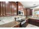 A well-equipped kitchen features custom cabinets, granite counters, stainless steel appliances, and tile backsplash at 2762 E Clifton Ave, Gilbert, AZ 85295