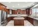 An open kitchen with dark wood cabinets, stainless appliances, a central island and a view to the backyard at 2762 E Clifton Ave, Gilbert, AZ 85295