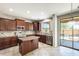 Beautiful kitchen with dark wood cabinets, stainless appliances, an island, and a view to the backyard patio at 2762 E Clifton Ave, Gilbert, AZ 85295