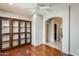 Spacious living area featuring a ceiling fan, wood floors, and a custom built-in bookcase at 2762 E Clifton Ave, Gilbert, AZ 85295