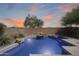 Tranquil backyard pool featuring rock accents, and desert landscaping under a colorful sunset sky at 2762 E Clifton Ave, Gilbert, AZ 85295