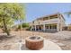 Expansive backyard featuring a fire pit, desert landscaping and view of the back of the house with a balcony at 28054 N Jade St, San Tan Valley, AZ 85143