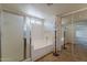 Bright bathroom featuring a glass-enclosed shower, soaking tub, and mirrored closet doors at 28054 N Jade St, San Tan Valley, AZ 85143