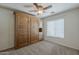 Guest bedroom with a built-in Murphy bed, ceiling fan, carpet, and a window providing natural light at 28054 N Jade St, San Tan Valley, AZ 85143