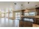 Well-lit kitchen boasts a breakfast bar, stainless appliances, tile backsplash, and adjacent living spaces at 28054 N Jade St, San Tan Valley, AZ 85143