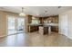 Modern kitchen with dark wood cabinetry, a center island, stainless steel appliances, and sliding door access at 28054 N Jade St, San Tan Valley, AZ 85143