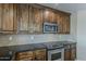 Close up of the kitchen showcasing dark cabinets, granite counters, a tile backsplash, and stainless appliances at 28054 N Jade St, San Tan Valley, AZ 85143
