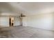 Expansive living room with neutral carpet, ceiling fan, and open layout to adjoining rooms at 28054 N Jade St, San Tan Valley, AZ 85143