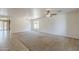 Spacious living room with carpet flooring, ceiling fan, and ample natural light, perfect for relaxation at 28054 N Jade St, San Tan Valley, AZ 85143