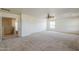 Well-lit living room showcasing neutral carpeting, ceiling fan, and an open entryway to the upper floor at 28054 N Jade St, San Tan Valley, AZ 85143