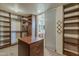 Large walk-in closet with custom wood shelving, drawers, and ample storage space at 28054 N Jade St, San Tan Valley, AZ 85143
