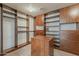 Spacious walk-in closet featuring custom wood shelving, drawers, and a central storage island at 28054 N Jade St, San Tan Valley, AZ 85143