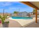 Backyard view of a refreshing private pool surrounded by a concrete deck and an outbuilding at 301 N 87Th St, Mesa, AZ 85207