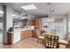Bright kitchen featuring wood cabinets, skylight and breakfast nook with modern chandelier and a view of the living room at 3301 S Goldfield Rd # 1046, Apache Junction, AZ 85119