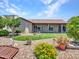 Manicured backyard with artificial turf, mature landscaping, and covered patio of the single story home at 3702 N 160Th Ave, Goodyear, AZ 85395
