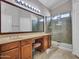 Bathroom featuring dual sinks, vanity, and a glass door shower with tile surround at 3702 N 160Th Ave, Goodyear, AZ 85395