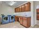 Spacious laundry room featuring a sink, granite countertop, cabinets, and modern blue washer and dryer at 3702 N 160Th Ave, Goodyear, AZ 85395