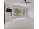 Bright living room featuring neutral carpeting, a ceiling fan, and large windows with backyard views at 3702 N 160Th Ave, Goodyear, AZ 85395
