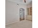 Carpeted room featuring an arched entry and a built-in storage unit at 3702 N 160Th Ave, Goodyear, AZ 85395
