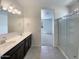 Bathroom with dual sinks, large mirror, and glass-enclosed shower at 37711 W Bello Ln, Maricopa, AZ 85138