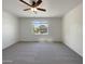 Empty bedroom with carpet and a ceiling fan, bathed in natural light from a window at 37711 W Bello Ln, Maricopa, AZ 85138