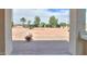 Spacious backyard with a brick patio, low shrubs, trees, and neutral landscaping at 40232 W Marion May Ln, Maricopa, AZ 85138